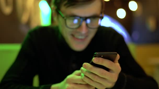 Junger Mann benutzt Smartphone im Café — Stockvideo