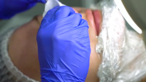 Kosmetička dělá postup pro ruční čištění žena tvář — Stock video