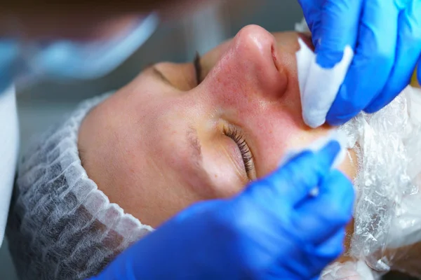 Kosmetolog gør proceduren for rengøring kvinde ansigt - Stock-foto