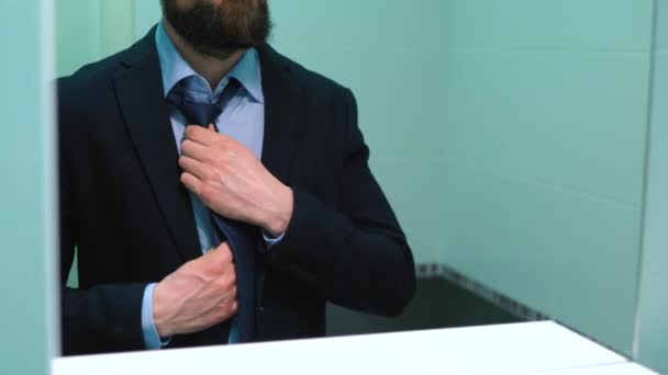 Beared businessman in glasses tying a tie — Stock Video