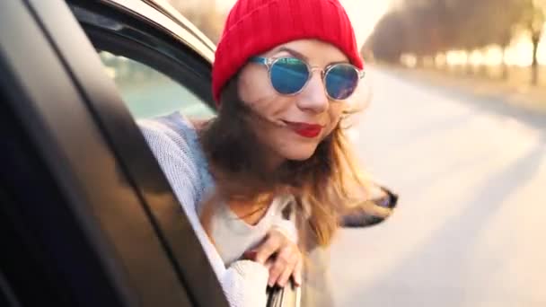 Boldog, fiatal nő ült az autó utasülés, és kinézett az ablakon a napsütéses napon — Stock videók