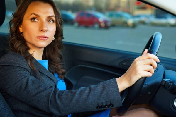 Donna si siede in una macchina in un parcheggio vicino a un centro commerciale — Foto Stock