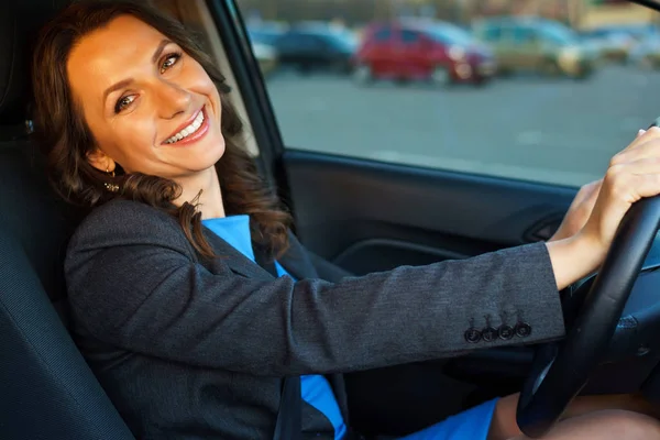 Vrouw zit in een auto in een parkeergarage in de buurt van een winkelcentrum — Stockfoto