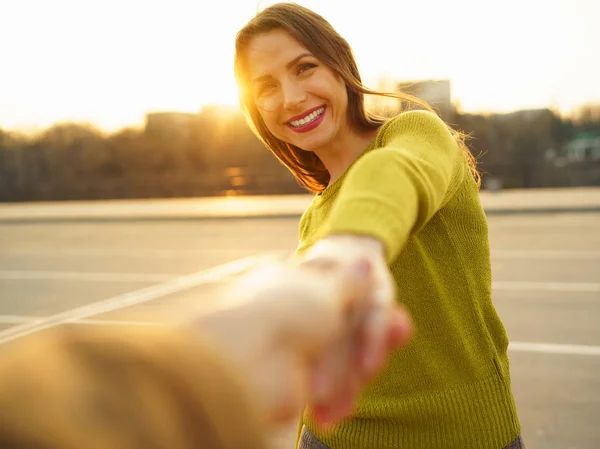 Volg mij - gelukkige jonge vrouw trekken guy's hand - hand in hand — Stockfoto