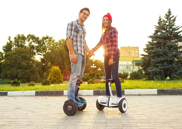 Young couple riding hoverboard - electrical scooter, personal ec — Stock Photo, Image