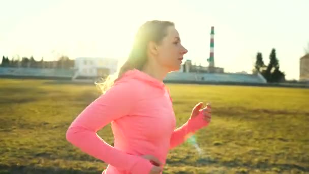 女人在日落时分穿过体育场 — 图库视频影像