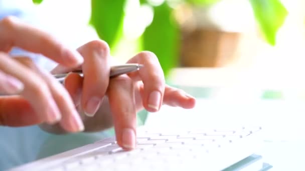 Жінка-офіс працівник друкує на клавіатурі і робить нотатки на папері — стокове відео