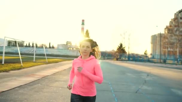 Kobieta biegnie przez stadion o zachodzie słońca — Wideo stockowe