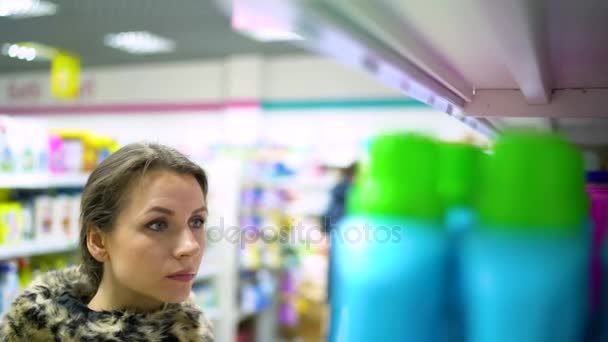 Mujer está de compras en la tienda de productos químicos domésticos y cosméticos — Vídeos de Stock