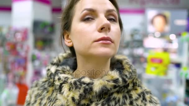 Женщина делает покупки в магазине бытовой химии и косметики — стоковое видео