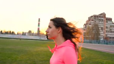 Kadın stadyumun günbatımında çalışır.