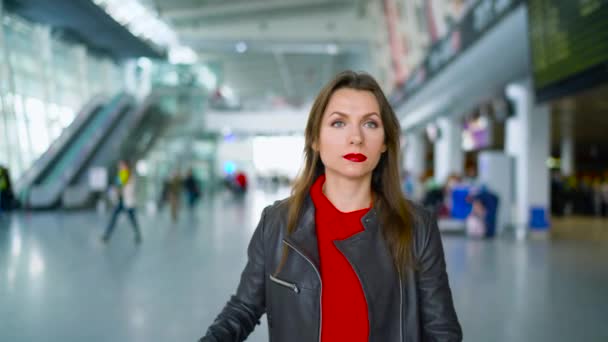 Frau in heller Kleidung rollt gelben Koffer auf Flughafen — Stockvideo