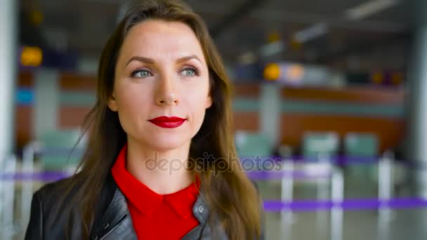 Kvinna i ljusa kläder är rullande gul resväska på flygplatsen — Stockvideo