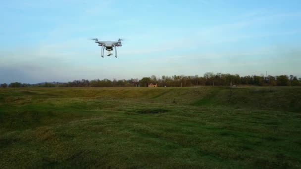 White copter flying over the green grass at sunset — Stock Video