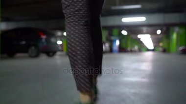 Kadın arabasına gider, kapıyı açar ve içinde oturur