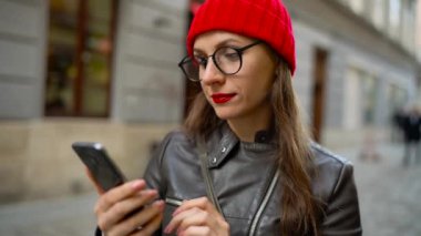 Kadın eski şehrin turistik fotoğraflar tarafından smartphone yapar ve Ortaçağ cadde boyunca elini kolunu sallaya dönüyor