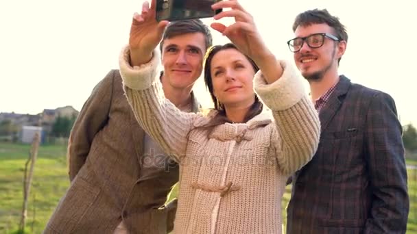 Des amis souriants font du selfie à l'extérieur — Video