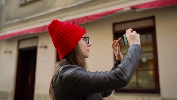 Kobieta sprawia, że zdjęcia atrakcji Starego miasta przez smartfon i spacery wzdłuż ulicy średniowieczny — Wideo stockowe