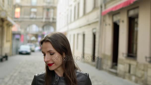 Žena s červenými rty používá smartphone a procházky podél středověké ulice — Stock video