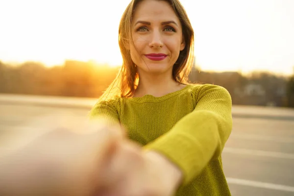 Feliz joven mujer tirando de la mano del chico - mano en mano caminando en un — Foto de Stock