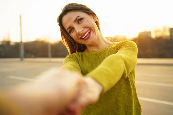 Glad ung kvinna dra killens hand - hand i hand gå på en — Stockfoto