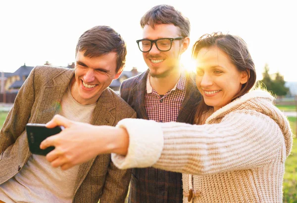Sorrindo amigos fazendo selfie ao ar livre — Fotografia de Stock