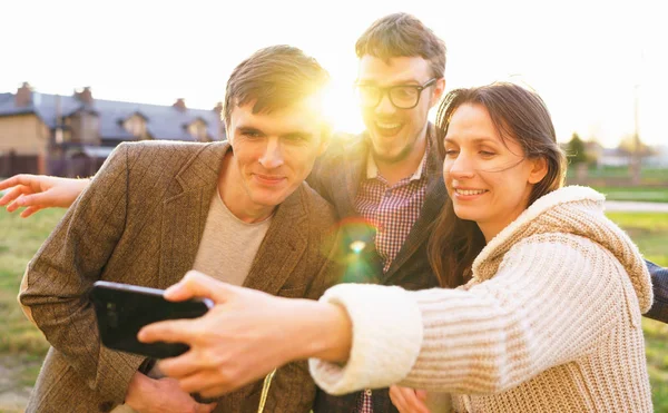 Sorrindo amigos fazendo selfie ao ar livre — Fotografia de Stock