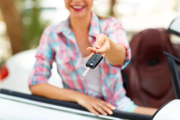 Mujer bonita joven está de pie cerca del coche descapotable con el —  Fotos de Stock