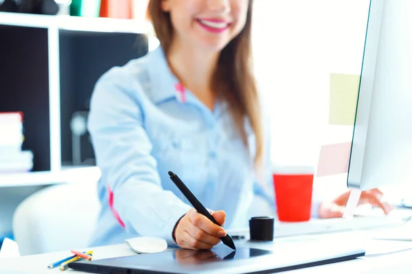 Женщина рисует что-то на графическом планшете в главном офисе — стоковое фото