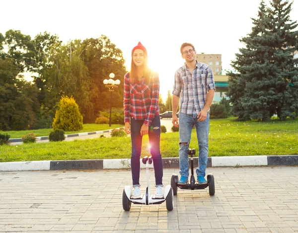 Young couple riding hoverboard - electrical scooter, personal ec — Stock Photo, Image