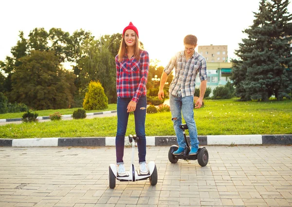 Pareja joven montando hoverboard - scooter eléctrico, eco personal — Foto de Stock