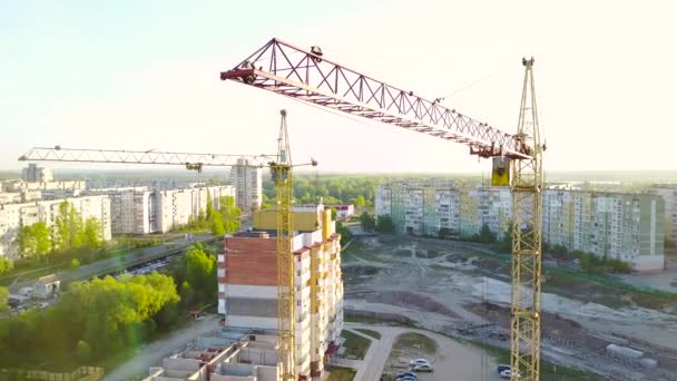 Grúas de construcción industrial y siluetas de construcción sobre el sol al amanecer — Vídeos de Stock