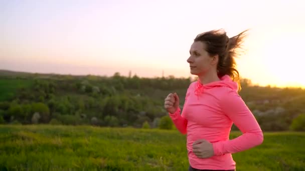 Mulher corre ao ar livre ao pôr do sol, câmera lenta — Vídeo de Stock