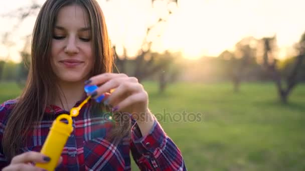 Mujer soplando burbujas de jabón al aire libre — Vídeos de Stock