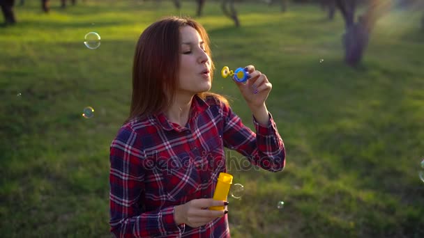 Femme soufflant des bulles de savon à l'extérieur au ralenti — Video