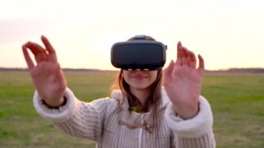 Kız açık havada bir sanal gerçeklik gözlük kullanır