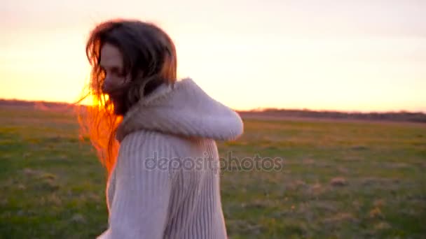 Женщина бежит по широкому полю на закате, замедленная съемка — стоковое видео