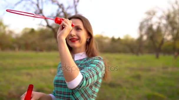 Woman blowing soap bubbles outdoors - slow motion — Stock Video