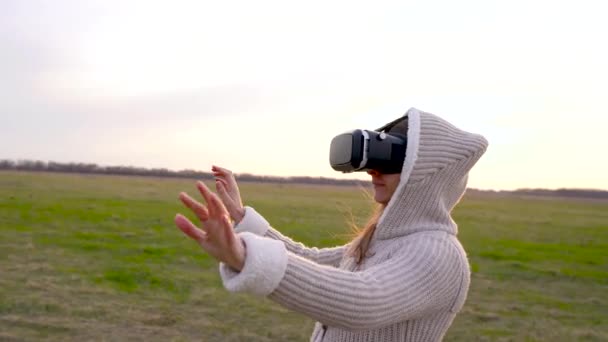 Flicka använder en virtual reality-glasögon utomhus — Stockvideo