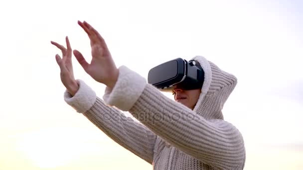 Девушка использует очки виртуальной реальности на открытом воздухе — стоковое видео
