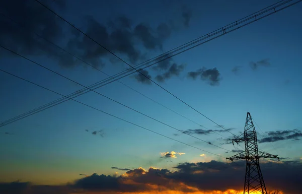Γραμμές μεταφοράς ενέργειας ενάντια στον ουρανό στο ηλιοβασίλεμα — Φωτογραφία Αρχείου