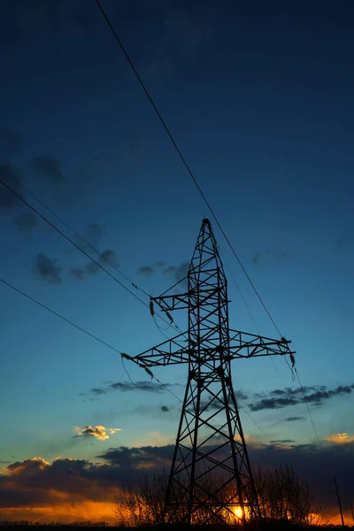 Kraftledningar mot himlen vid solnedgången — Stockfoto