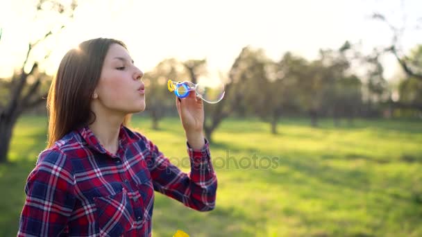 Žena venku fouká mýdlové bubliny — Stock video