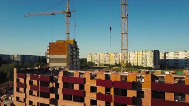 Endüstriyel İnşaat vinçleri ve güneş batımında üzerinde binalar