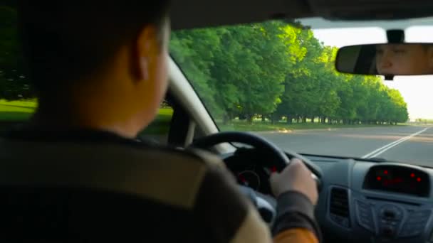 Dikke man rijdt een auto bij zonsondergang — Stockvideo