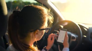 Arabada bir smartphone kullanarak gözlüklü kadın