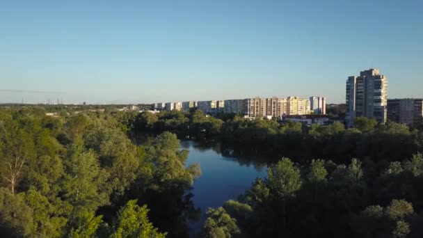 Survoler les arbres et le lac de la ville à l'aube - enregistrement vidéo aérien 