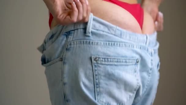 Woman pulls her jeans on her buttocks with cellulite — Stock Video