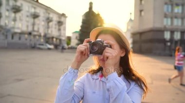 Kız şehir ve turistik fotoğraflarını alarak çevresinde bir film kamerası üzerinde yürüyor