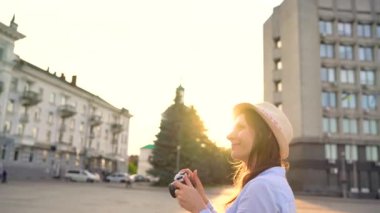 Kız şehir ve turistik fotoğraflarını alarak çevresinde bir film kamerası üzerinde yürüyor